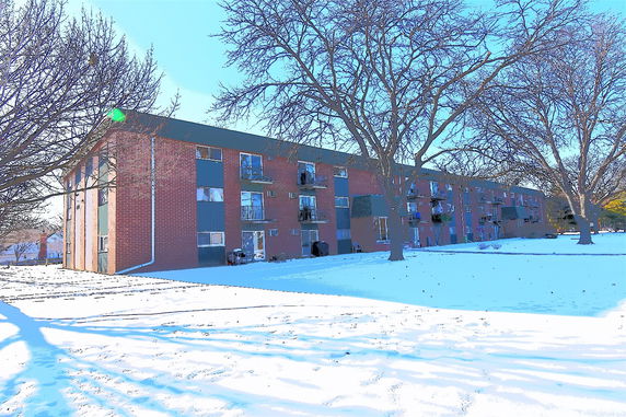 Front view of a three-story brick apartment building.