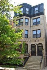 Front view of a multi-story residential building with stairs leading to the entrance.