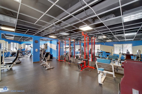 Interior view of a gym with various exercise equipment and blue walls.