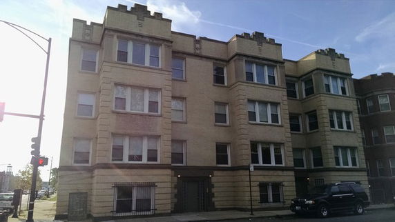 Front view of a multi-story apartment building with multiple windows.