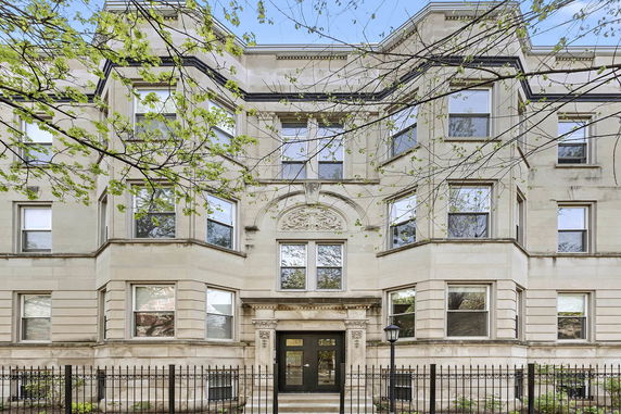 Front view of a multi-story residential building with detailed architectural features.