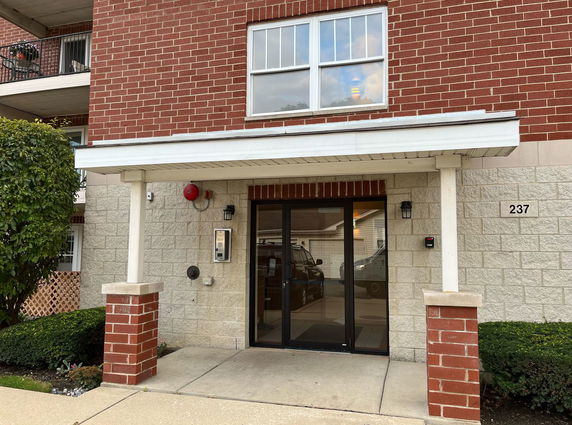 Front view of a building with brick and stone facade and entrance door.