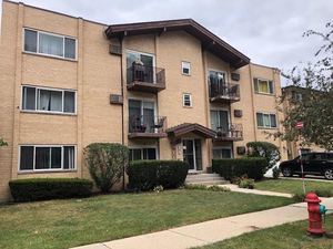 Front view of a three-story brick apartment building with balconies.