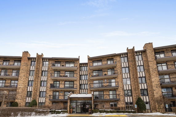 Front view of a multi-story apartment building with balconies.