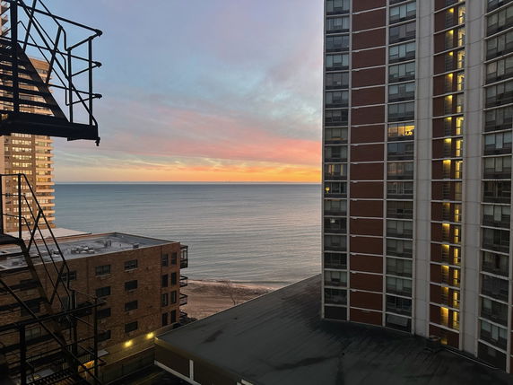 View of high-rise buildings near a body of water during sunset.