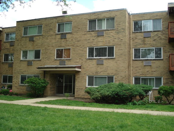 Front view of a three-story brick apartment building.