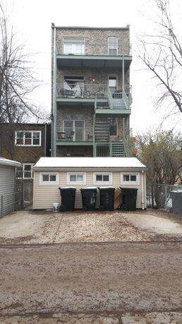 Rear view of a multi-story building with external staircases.