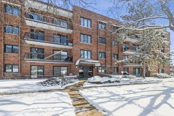 Front view of a multi-story brick apartment building in winter.