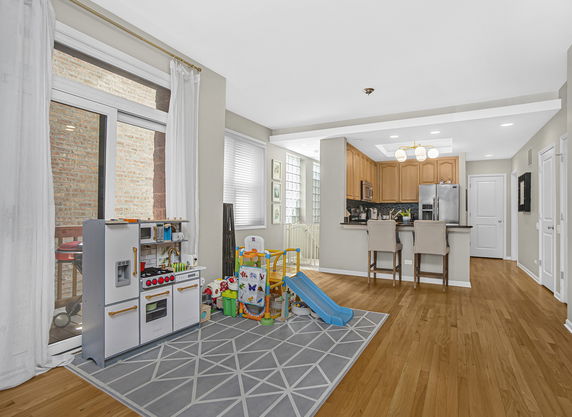 Room with a small indoor play area and a kitchen in the background.