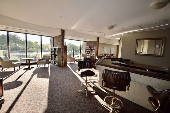 Interior view of a lounge area with seating and bookshelves.