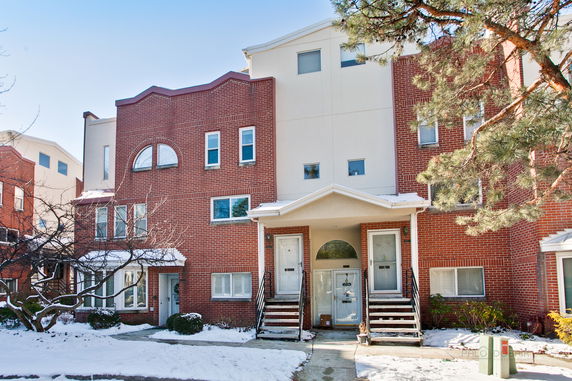 Front view of a multi-story brick building with two entrance doors.