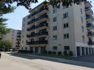 Front view of a multi-story apartment building with balconies.