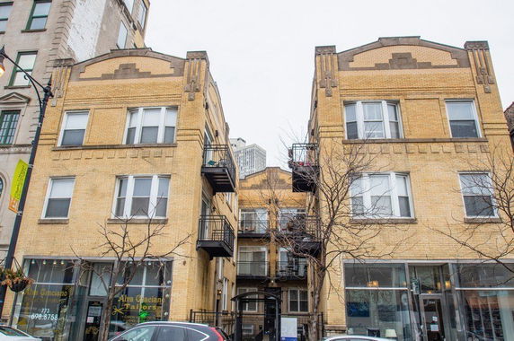 Front view of a multi-story residential building with balconies.
