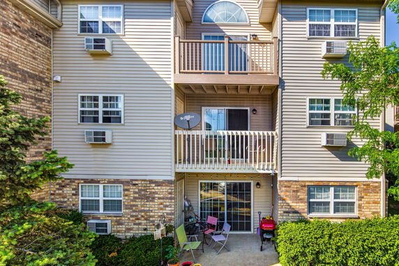 Front view of a multi-story residential building with balconies and large windows.