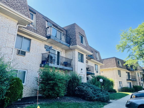 Front view of an apartment building with multiple stories and balconies.