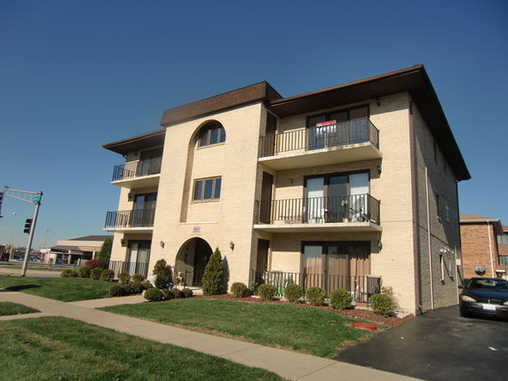 Front view of a three-story apartment building with balconies.