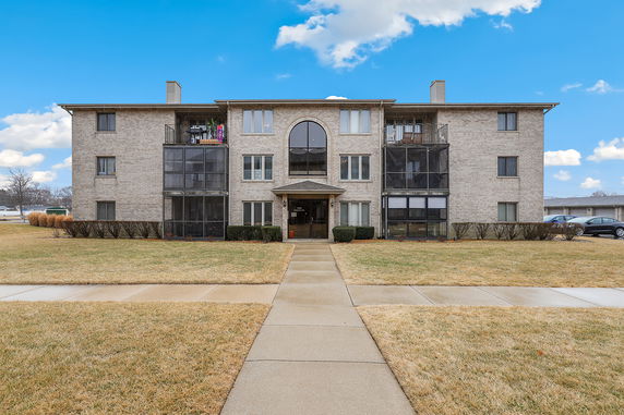 Front view of a three-story apartment building with balconies.