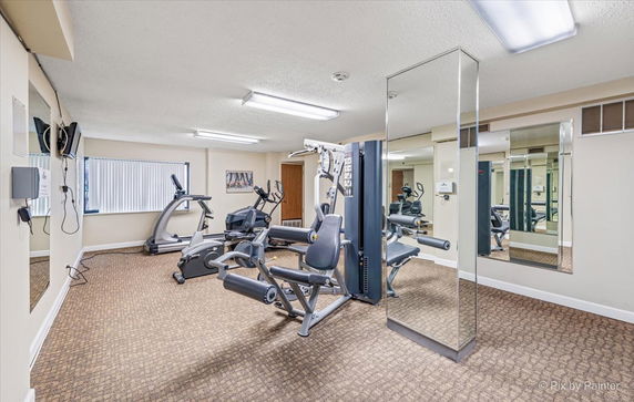 Interior view of a gym with exercise equipment and mirrors.