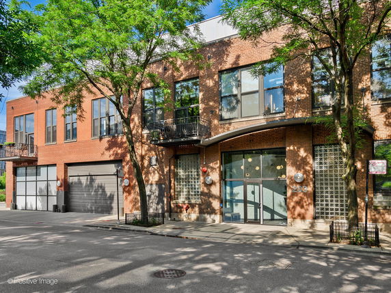 Front view of a two-story brick building with large windows and a garage.