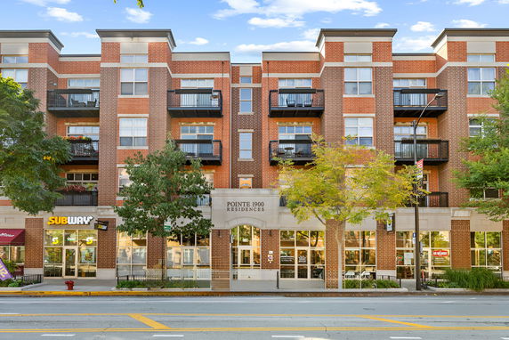 Front view of a multi-story residential building with commercial spaces on the ground floor.