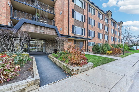Front view of a multi-story brick apartment building with balconies.