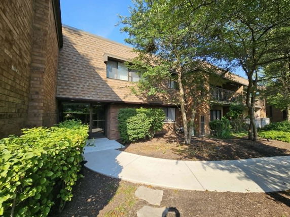 Front view of a two-story building with brick exterior and sloped roof.