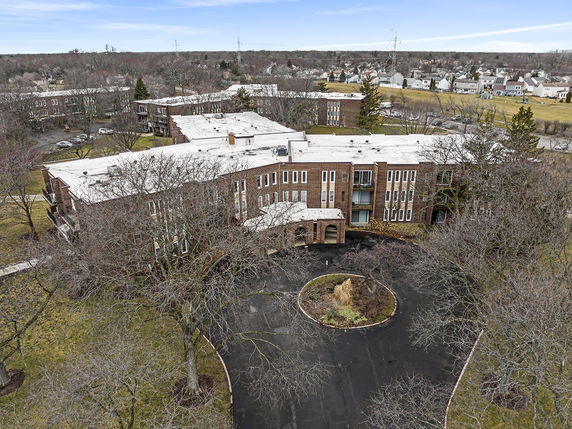 Front view of a large multi-story brick building with a circular driveway.
