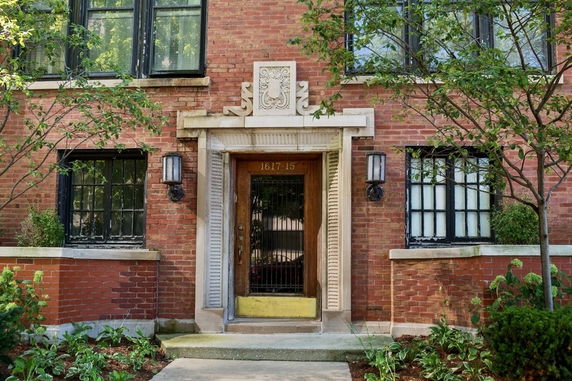 Front view of a brick building entrance with decorative stonework.