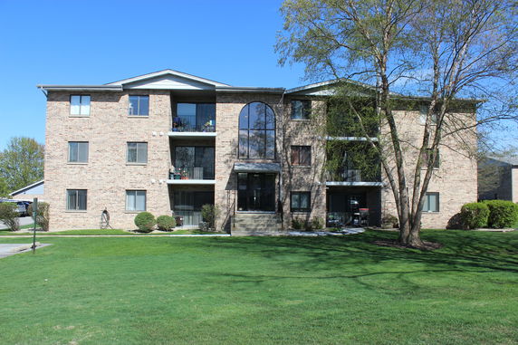Front view of a multi-story apartment building with balconies.