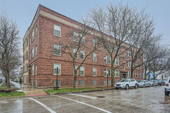 Front view of a multi-story brick building on a corner.