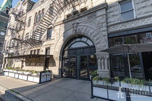 Front view of a historic multi-story building with arched entrance.