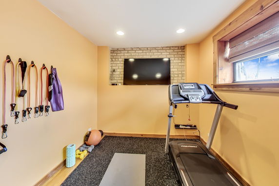 Interior view of a home gym with exercise equipment and a treadmill.