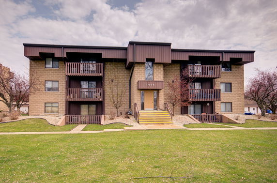 Front view of a three-story apartment building with balconies.