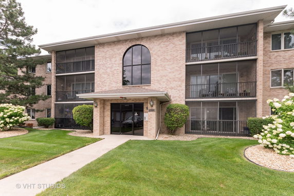 Front view of a multi-story apartment building with balconies.