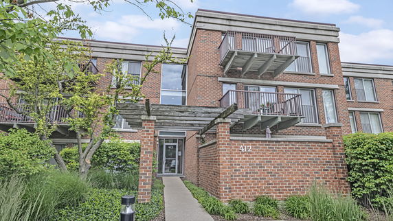 Front view of a brick apartment building with balconies.