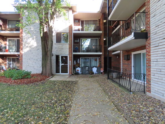 Front view of a multi-story apartment building with balconies.