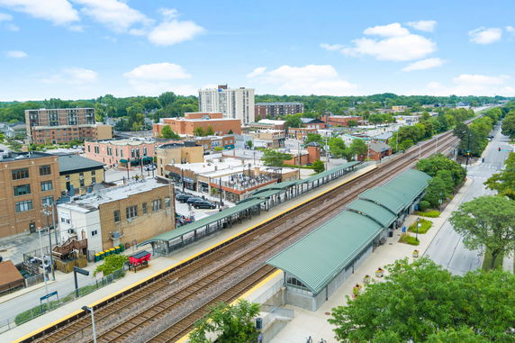 Panoramic view of a town with buildings and a train station visible.