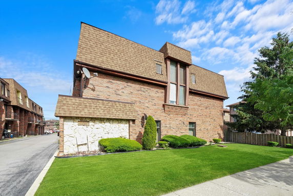 Front view of a multi-story brick building with a distinctive roof design.