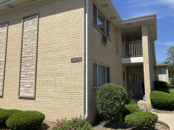 Front view of a two-story brick building with a small balcony.