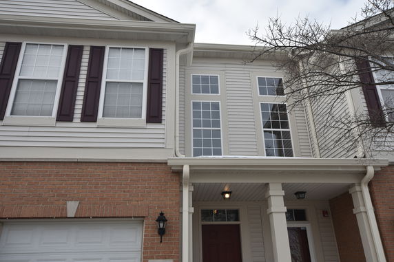 Front view of a two-story house with brick and siding exterior.