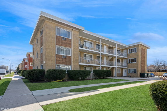 Front view of a three-story apartment building with balconies.