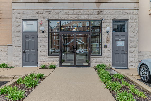 Front view of a building entrance with stone facade and glass door.
