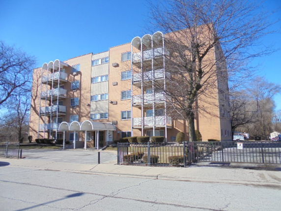 Front view of a multi-story apartment building with balconies.