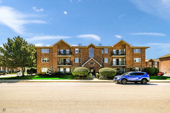 Front view of a multi-story brick building with balconies.