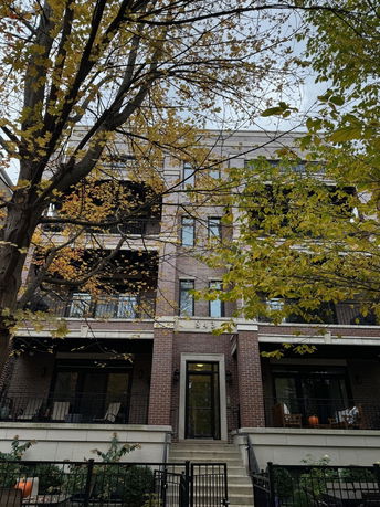 Front view of a multi-story brick building with balconies.