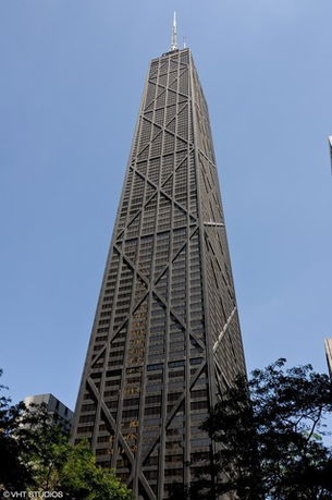 Front view of a tall skyscraper with a prominent structural design.