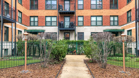 Front view of a brick apartment building with multiple balconies.