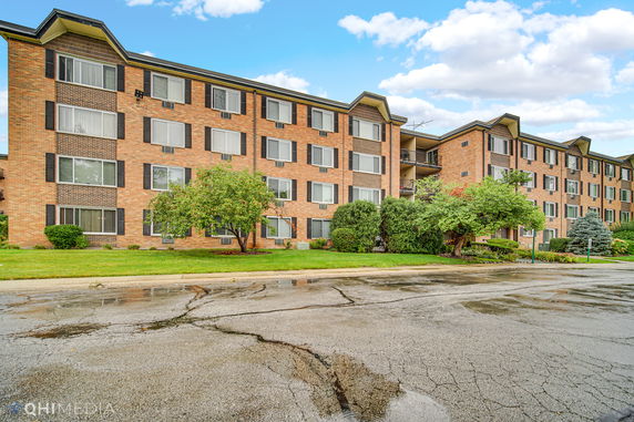 Front view of a four-story brick apartment building.