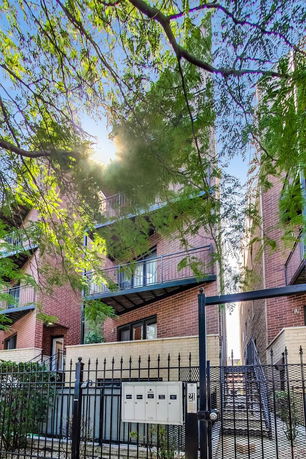Front view of a multi-story brick building with balconies.