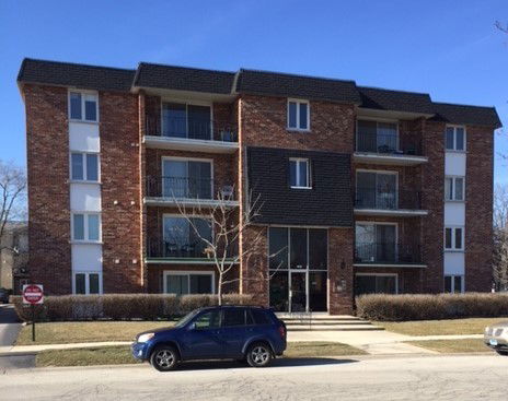 Front view of a multi-story apartment building with balconies.
